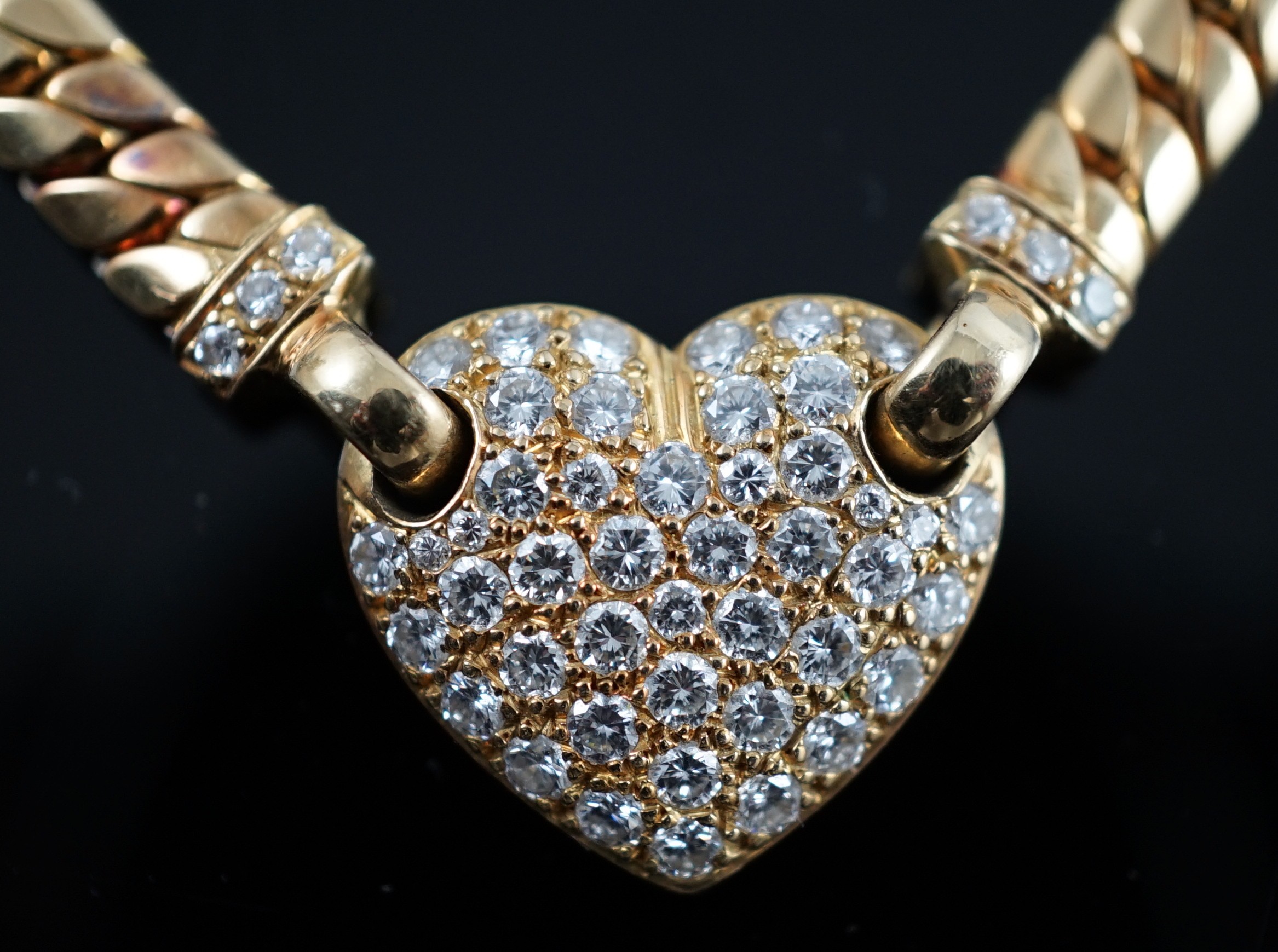 A modern 18ct gold and pave set diamond heart shaped pendant necklace